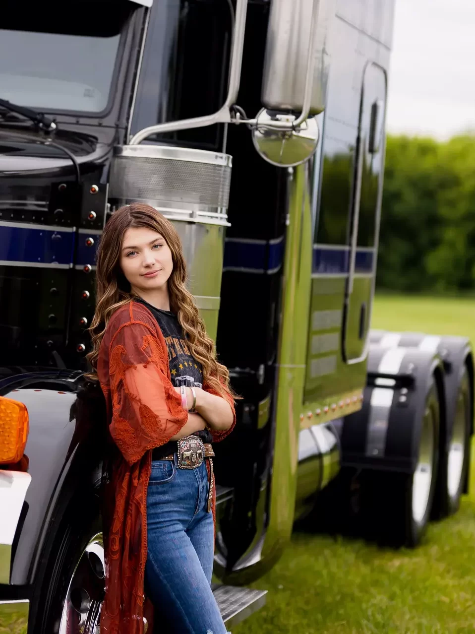 Scholarship recipient Abby Redman leans against a Peterbilt bobtail cab.